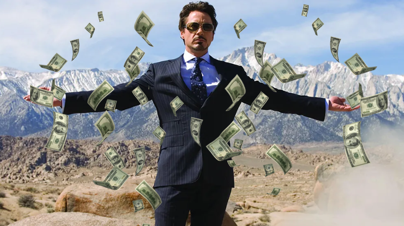 A business man with arms open and money falling around him.